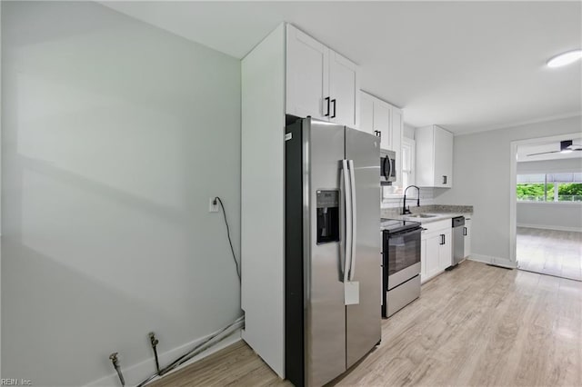 111 S Lloyd St, Suffolk, VA 23434 - kitchen with appliances with stainless steel finishes, a sink, white cabinets, and light wood-style flooring