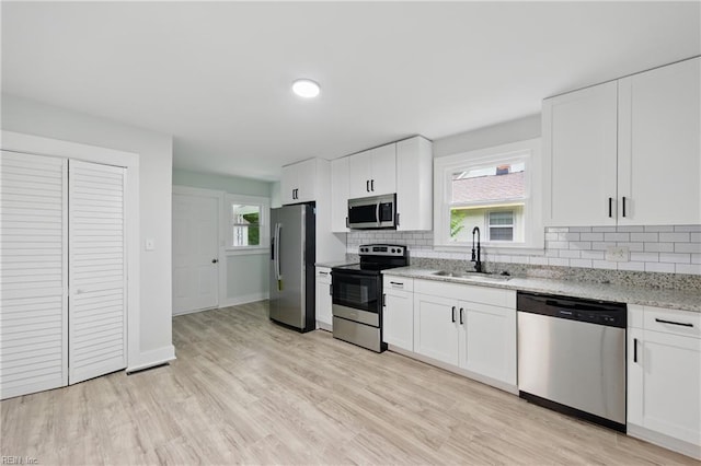 111 S Lloyd St, Suffolk, VA 23434 - kitchen featuring stainless steel appliances, a sink, decorative backsplash, light stone countertops, and white cabinets
