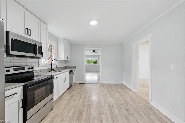 111 S Lloyd St, Suffolk, VA 23434 - kitchen featuring appliances with stainless steel finishes, a sink, ornamental molding, light wood-style floors, and decorative backsplash