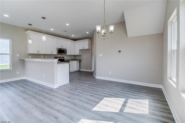 208 Beech St, Suffolk, VA 23434 - kitchen with appliances with stainless steel finishes, a peninsula, light wood finished floors, white cabinetry, and recessed lighting