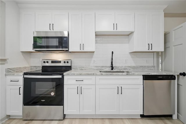 8715 Semmes Ave, Norfolk, VA 23503 - kitchen featuring appliances with stainless steel finishes, a sink, backsplash, and white cabinets