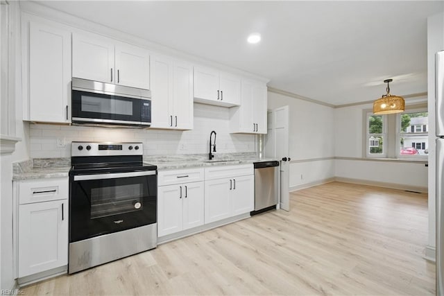 8715 Semmes Ave, Norfolk, VA 23503 - kitchen with appliances with stainless steel finishes, a sink, backsplash, light wood-style flooring, and ornamental molding