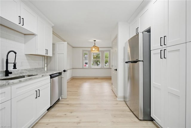 8715 Semmes Ave, Norfolk, VA 23503 - kitchen with appliances with stainless steel finishes, a sink, backsplash, white cabinets, and light wood-style flooring