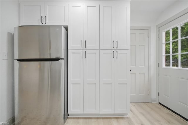 8715 Semmes Ave, Norfolk, VA 23503 - kitchen featuring freestanding refrigerator, light wood-style floors, and white cabinets