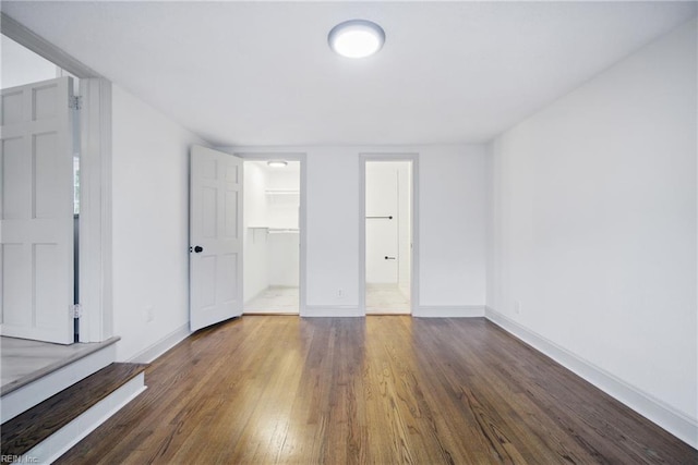 8715 Semmes Ave, Norfolk, VA 23503 - unfurnished bedroom featuring wood finished floors, baseboards, a walk in closet, and a closet