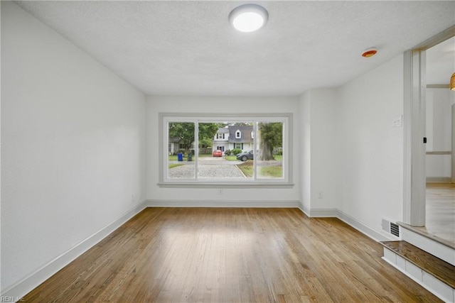 8715 Semmes Ave, Norfolk, VA 23503 - unfurnished room featuring wood finished floors, baseboards, and a textured ceiling