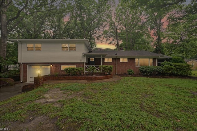 4629 Hermitage Rd, Virginia Beach, VA 23455 - tri-level home with brick siding, concrete driveway, a garage, and a front lawn