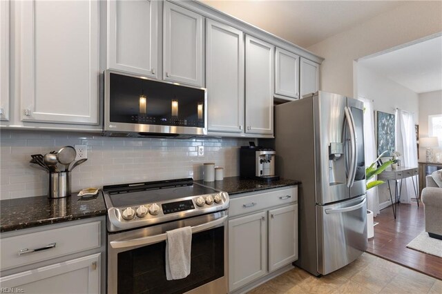 1025 Sullivan Ln, Chesapeake, VA 23322 - kitchen with appliances with stainless steel finishes, backsplash, and dark stone countertops