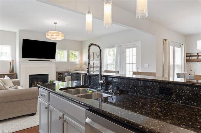 1025 Sullivan Ln, Chesapeake, VA 23322 - kitchen with a sink, open floor plan, dark stone counters, a fireplace, and pendant lighting