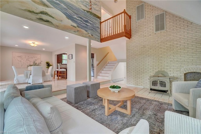 110 Olde Pond Ln, Yorktown, VA 23693 - living area with a wood stove, stairs, brick wall, recessed lighting, and a high ceiling