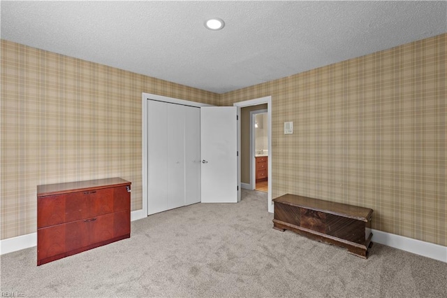 400 Discovery Rd, Virginia Beach, VA 23451 - unfurnished bedroom with carpet floors, a closet, wallpapered walls, a textured ceiling, and baseboards