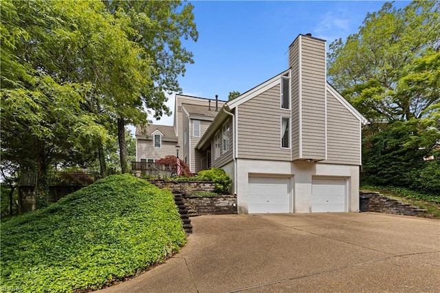 400 Discovery Rd, Virginia Beach, VA 23451 - view of side of property with a chimney, an attached garage, driveway, and stucco siding