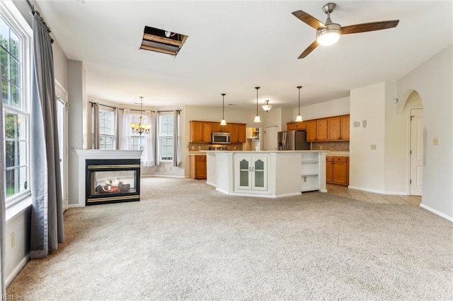 109 Lenora Cv, Smithfield, VA 23430 - unfurnished living room featuring light colored carpet, baseboards, a multi sided fireplace, arched walkways, and ceiling fan