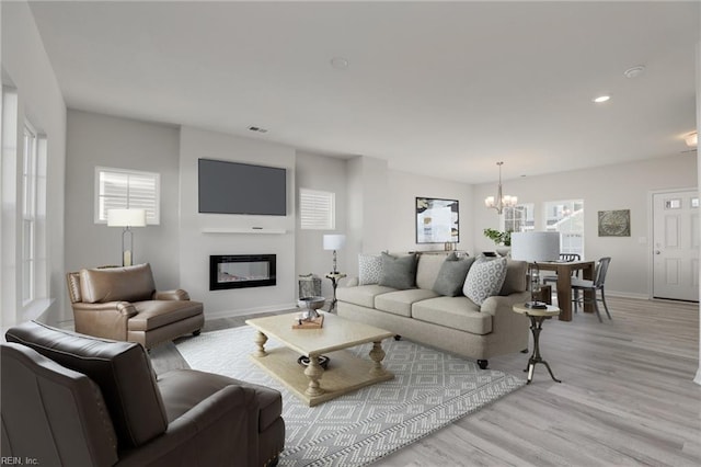 4408 Abercorn Dr, Suffolk, VA 23435 - living area with a chandelier, a glass covered fireplace, light wood-style flooring, recessed lighting, and baseboards