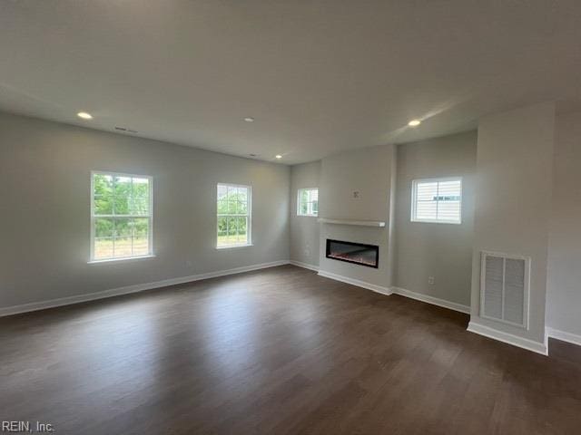 4408 Abercorn Dr, Suffolk, VA 23435 - unfurnished living room with dark wood-style flooring, plenty of natural light, baseboards, a glass covered fireplace, and recessed lighting