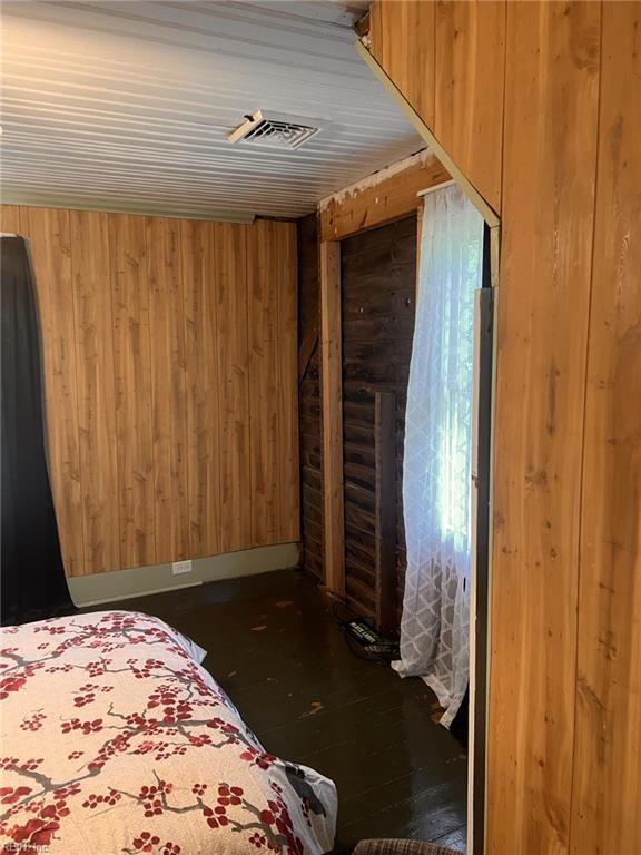 1717 Old Ferry Rd, Hudgins, VA 23076 - bedroom with wooden walls and hardwood / wood-style flooring