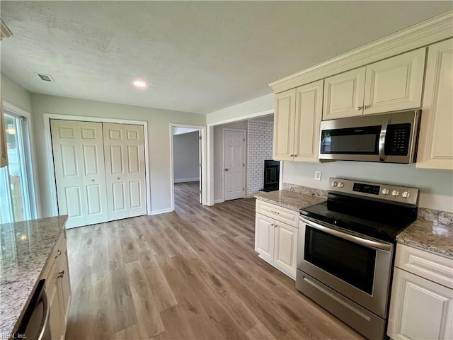 3300 Pine Hill Cres, Chesapeake, VA 23321 - kitchen with appliances with stainless steel finishes, light wood-style floors, light stone countertops, baseboards, and a textured ceiling