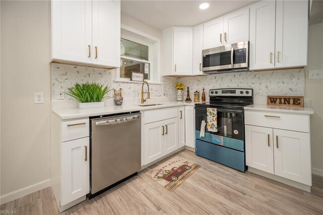 917 Garfield Ave, Suffolk, VA 23434 - kitchen with stainless steel appliances, a sink, white cabinets, backsplash, and light countertops