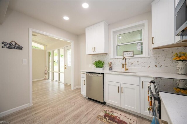917 Garfield Ave, Suffolk, VA 23434 - kitchen with stainless steel appliances, a sink, decorative backsplash, white cabinets, and light wood finished floors