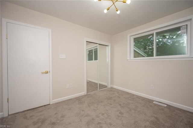 917 Garfield Ave, Suffolk, VA 23434 - unfurnished bedroom with carpet, a chandelier, baseboards, and a closet