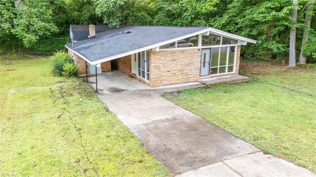 917 Garfield Ave, Suffolk, VA 23434 - mid-century modern home featuring driveway, stone siding, a front lawn, an attached carport, and a chimney