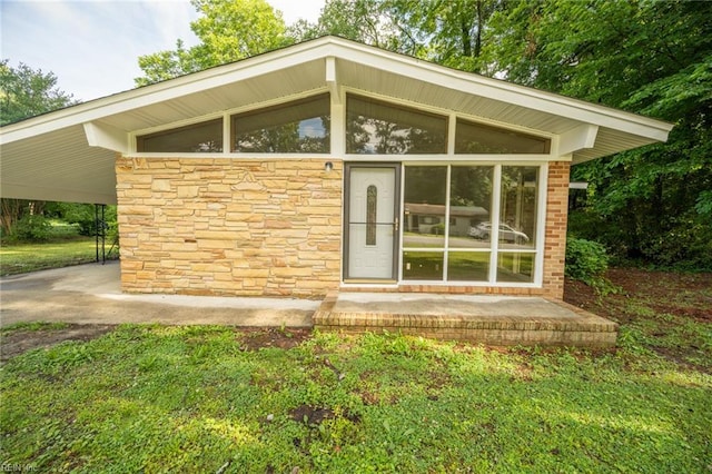 917 Garfield Ave, Suffolk, VA 23434 - back of property featuring stone siding, an attached carport, and a sunroom