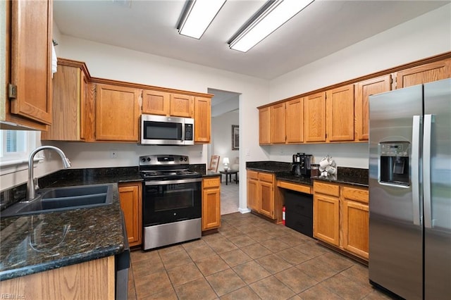 302 Peachwood Ct, Suffolk, VA 23434 - kitchen featuring stainless steel appliances, a sink, dark tile patterned floors, dark stone counters, and brown cabinets