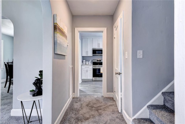319 Greenbriar Ave, Hampton, VA 23661 - hallway with arched walkways, light carpet, stairs, and baseboards
