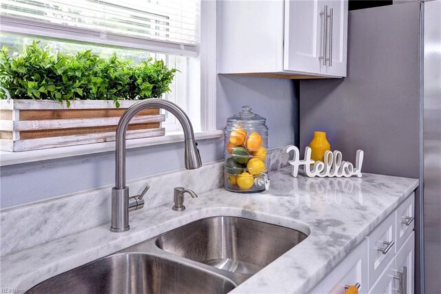 319 Greenbriar Ave, Hampton, VA 23661 - kitchen view of a sink, white cabinetry, and light stone counters