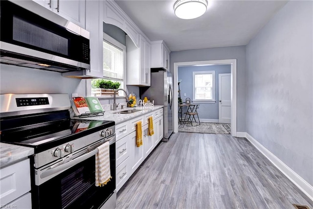 319 Greenbriar Ave, Hampton, VA 23661 - kitchen with stainless steel appliances, a sink, white cabinets, and light wood finished floors