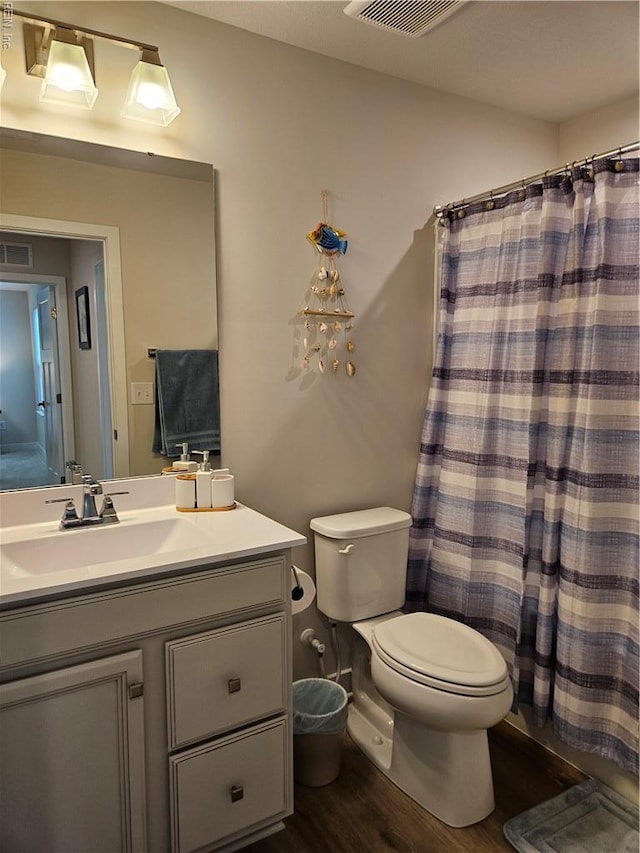 23082 Retreat Ln, Carrollton, VA 23314 - bathroom with wood finished floors, toilet, vanity, and curtained shower