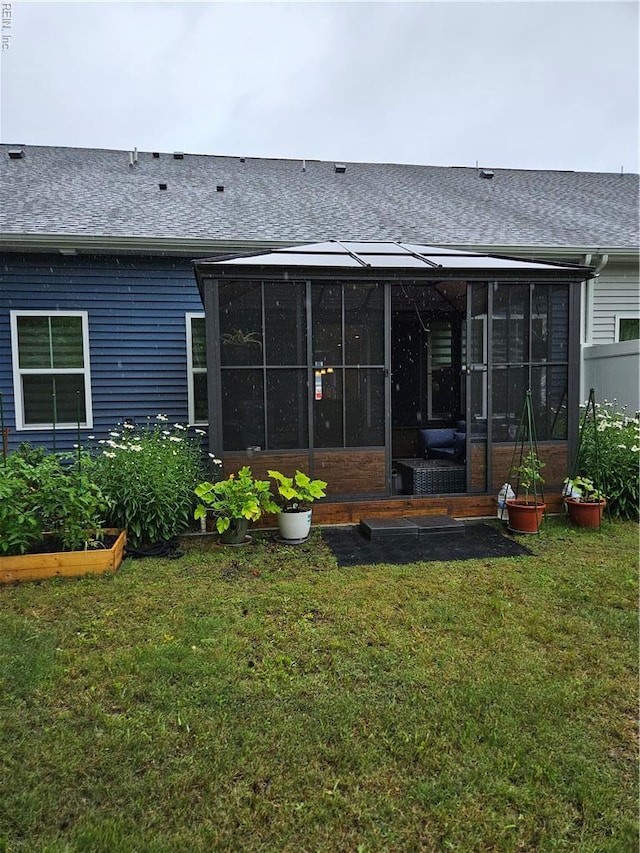 23082 Retreat Ln, Carrollton, VA 23314 - rear view of house with a sunroom, roof with shingles, a yard, and a garden