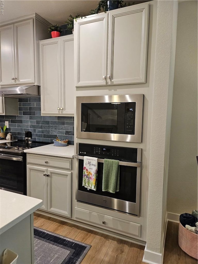 23082 Retreat Ln, Carrollton, VA 23314 - kitchen with stainless steel oven, built in microwave, range with electric stovetop, light wood-type flooring, and light countertops