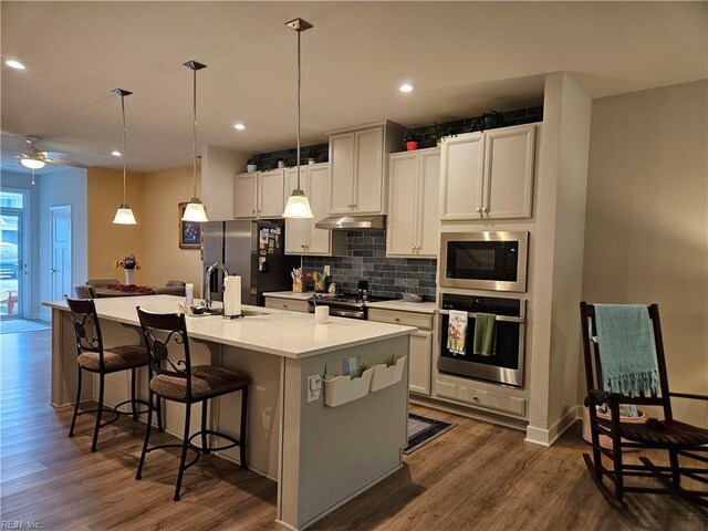 23082 Retreat Ln, Carrollton, VA 23314 - kitchen featuring stainless steel appliances, backsplash, dark wood-type flooring, under cabinet range hood, and recessed lighting
