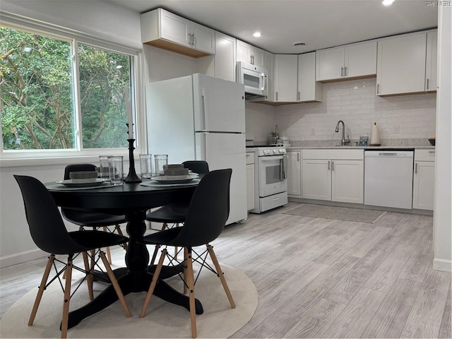 432 Maryle Ct, Newport News, VA 23602 - kitchen featuring white appliances, a sink, tasteful backsplash, light wood-type flooring, and white cabinetry