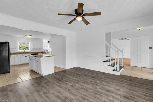 3005 Beech Grove Ln, Suffolk, VA 23435 - kitchen with freestanding refrigerator, ceiling fan, white cabinets, dark countertops, and a kitchen island
