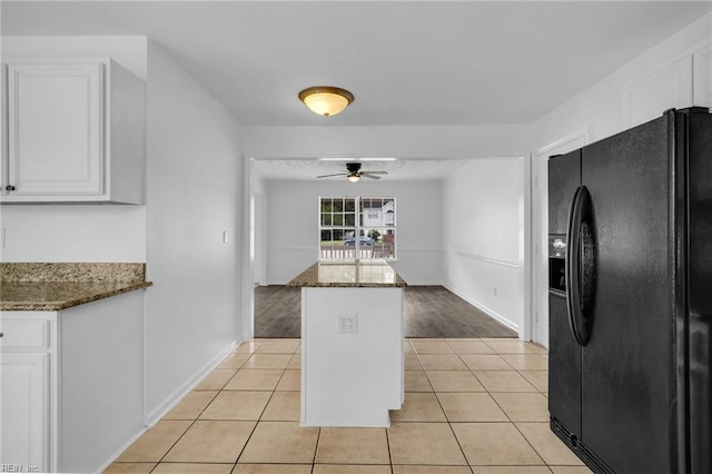 3005 Beech Grove Ln, Suffolk, VA 23435 - kitchen with black fridge, a ceiling fan, white cabinets, dark stone countertops, and light tile patterned floors