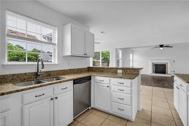 3005 Beech Grove Ln, Suffolk, VA 23435 - kitchen featuring stainless steel dishwasher, a sink, a fireplace with raised hearth, ceiling fan, and light tile patterned floors