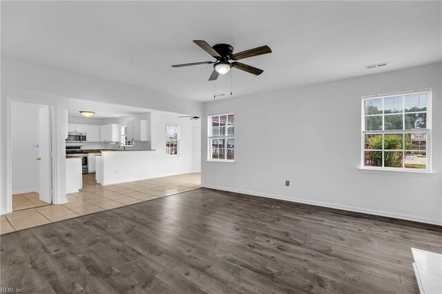 3005 Beech Grove Ln, Suffolk, VA 23435 - unfurnished living room featuring a ceiling fan, wood finished floors, and baseboards