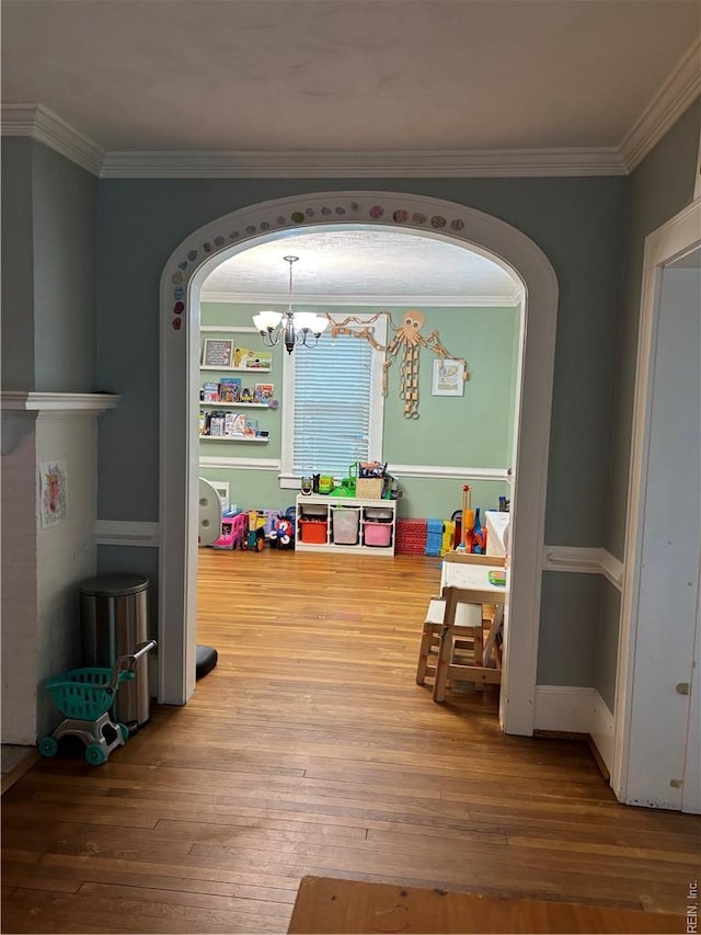 709 Smith St, Suffolk, VA 23434 - rec room with a chandelier, hardwood / wood-style flooring, ornamental molding, and arched walkways