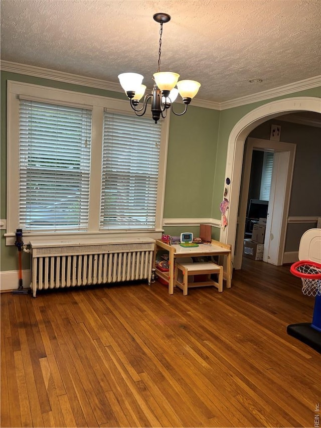 709 Smith St, Suffolk, VA 23434 - dining area featuring radiator, a chandelier, hardwood / wood-style floors, a textured ceiling, and arched walkways