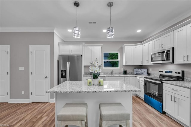 505 Osceola Ave, Suffolk, VA 23434 - kitchen featuring appliances with stainless steel finishes, ornamental molding, a sink, white cabinetry, and a center island