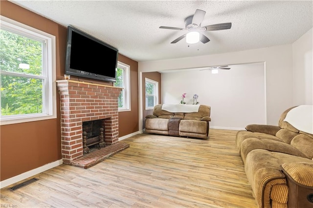 891 Bells Mill Rd, Chesapeake, VA 23322 - living room featuring a ceiling fan, a brick fireplace, light wood-style flooring, a textured ceiling, and baseboards
