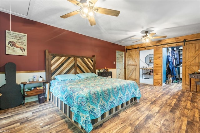 891 Bells Mill Rd, Chesapeake, VA 23322 - bedroom with a barn door, attic access, wood finished floors, wood walls, and a ceiling fan