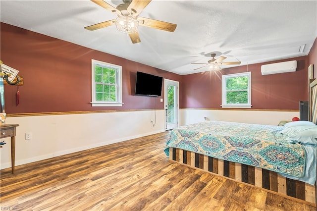 891 Bells Mill Rd, Chesapeake, VA 23322 - bedroom with a wall mounted air conditioner, wood finished floors, multiple windows, a ceiling fan, and a textured ceiling