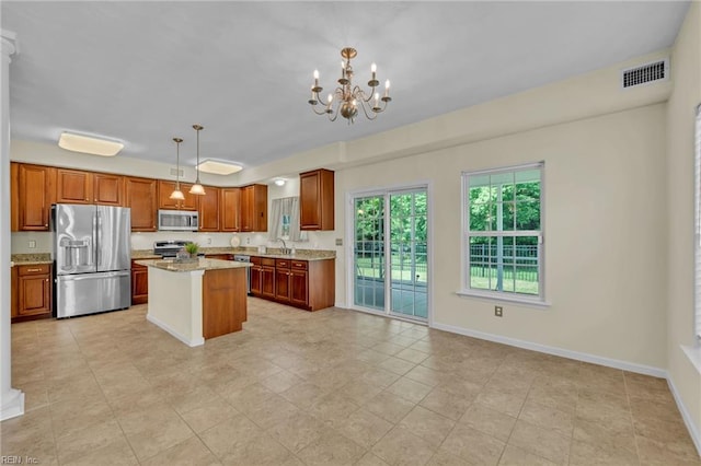 5018 Kings Grant Cir, Suffolk, VA 23434 - kitchen with stainless steel appliances, a chandelier, baseboards, hanging light fixtures, and brown cabinets