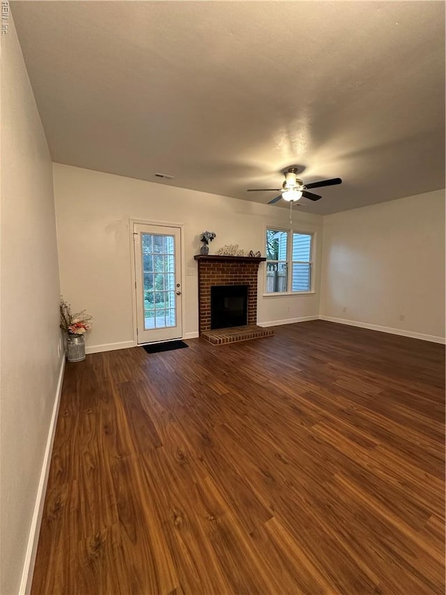 1183 Killington Arch, Chesapeake, VA 23320 - unfurnished living room featuring dark wood-type flooring, baseboards, ceiling fan, and a brick fireplace