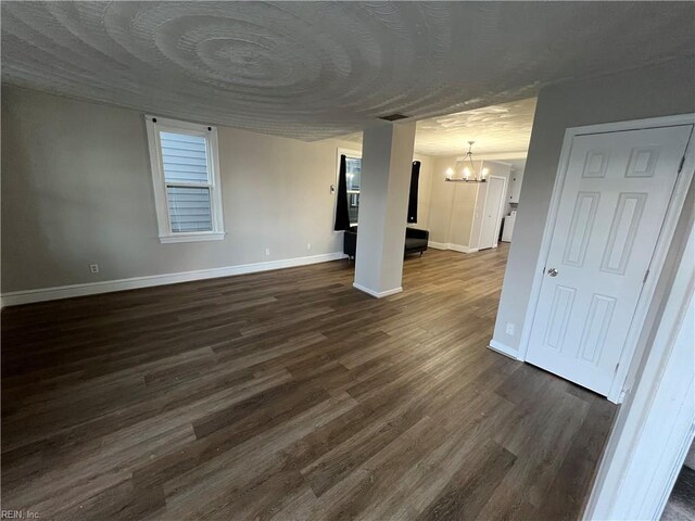 714 B St, Chesapeake, VA 23324 - unfurnished living room with a chandelier, baseboards, and dark wood-style flooring