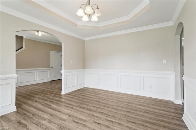 105 Brogden Ct, Hampton, VA 23666 - unfurnished room with arched walkways, a chandelier, wood finished floors, a tray ceiling, and a wainscoted wall