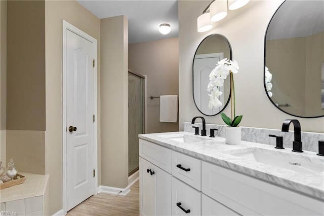 711 Windbrook Cir, Newport News, VA 23606 - bathroom featuring double vanity, a shower stall, baseboards, a bath, and wood finished floors